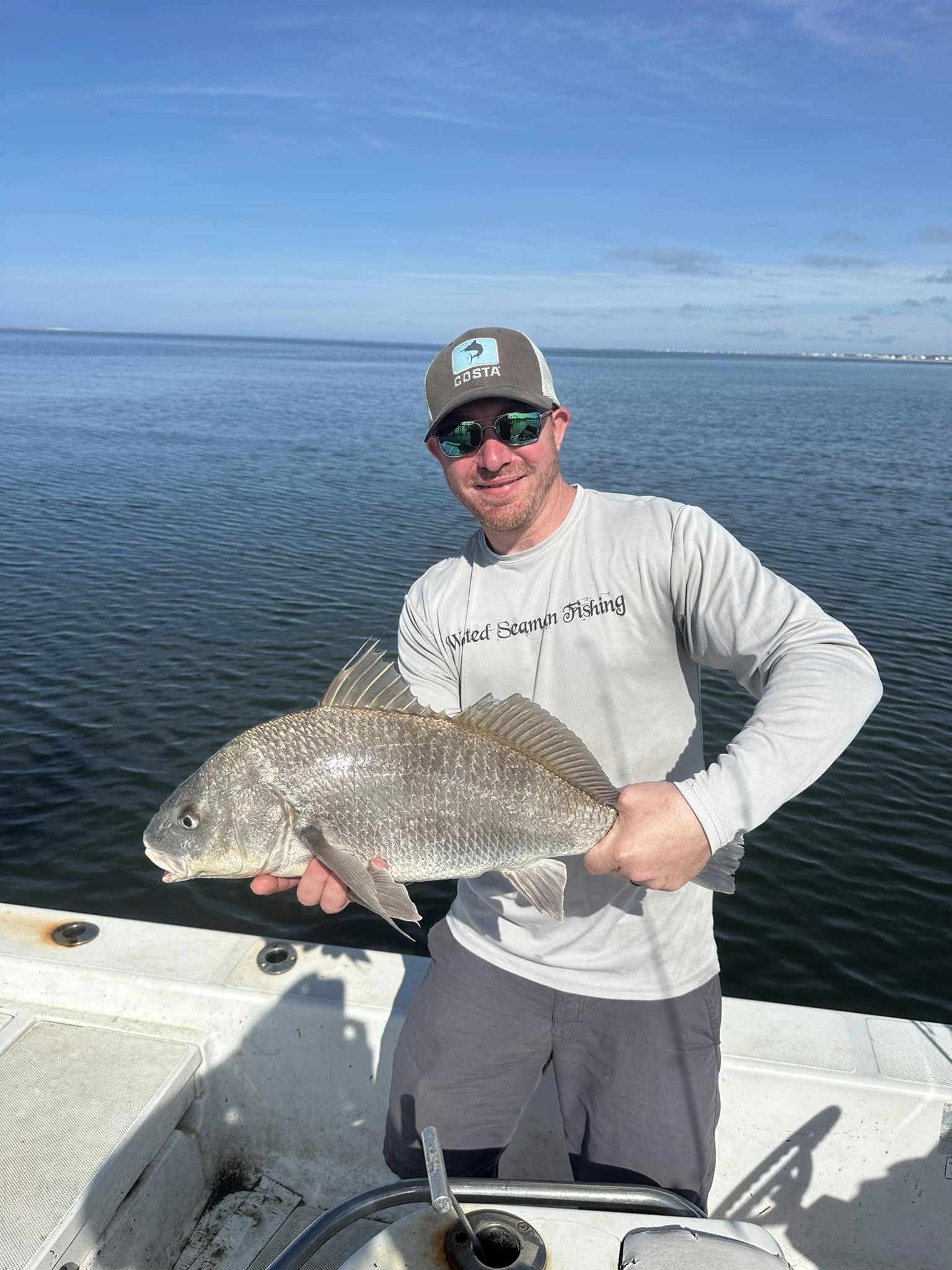 An angler holding a 16-inch Black Drum fish caught in FL.
