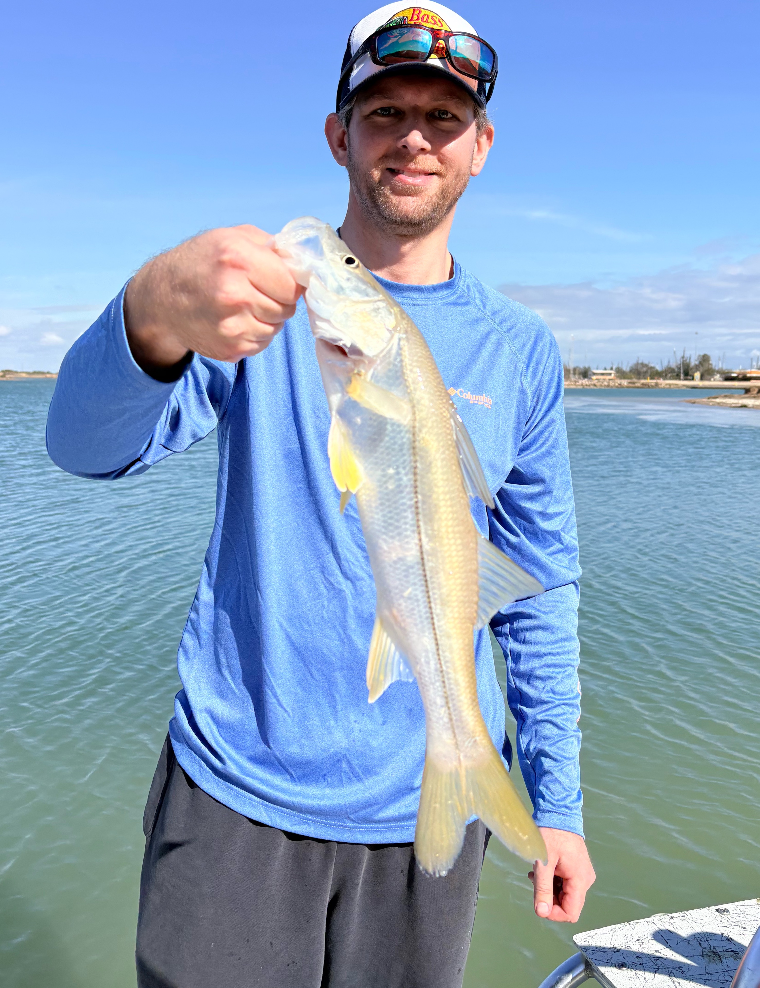 Angler with a fishing pole stands on the shore of South Padre Island
