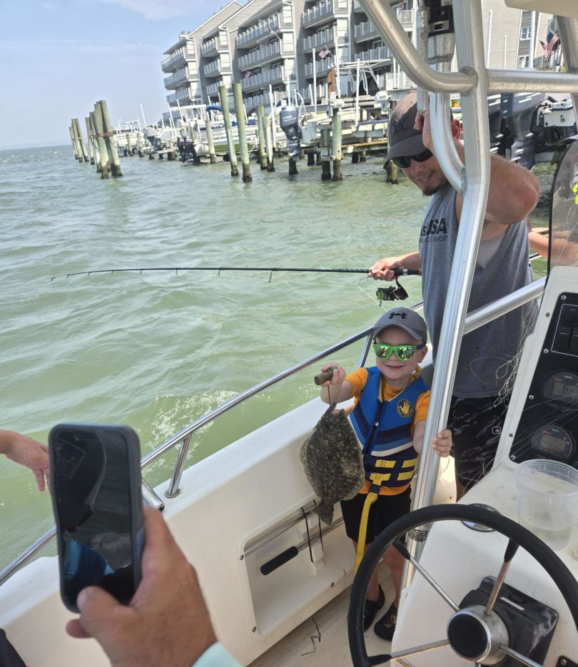 Angler holding a Southern Flounder fish in the ocean at Ocean City