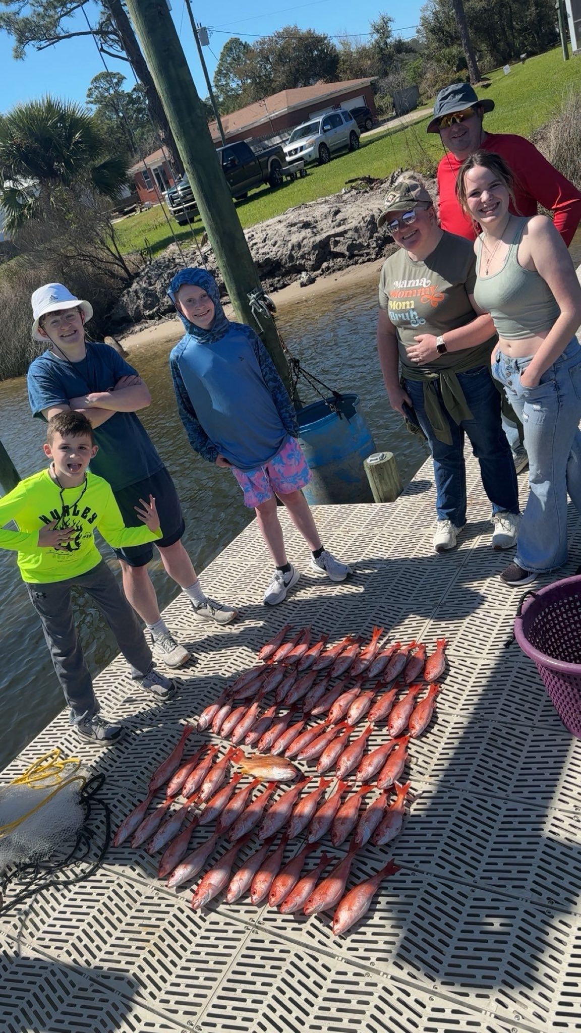 Family fishing trip in Pensacola FL with fresh caught fish displayed on dock