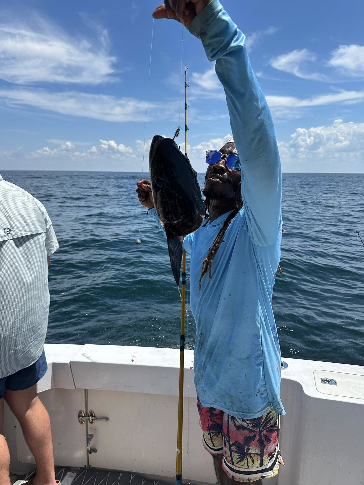 Deep sea fishing action with catch being pulled up on fishing boat in Pensacola FL waters
