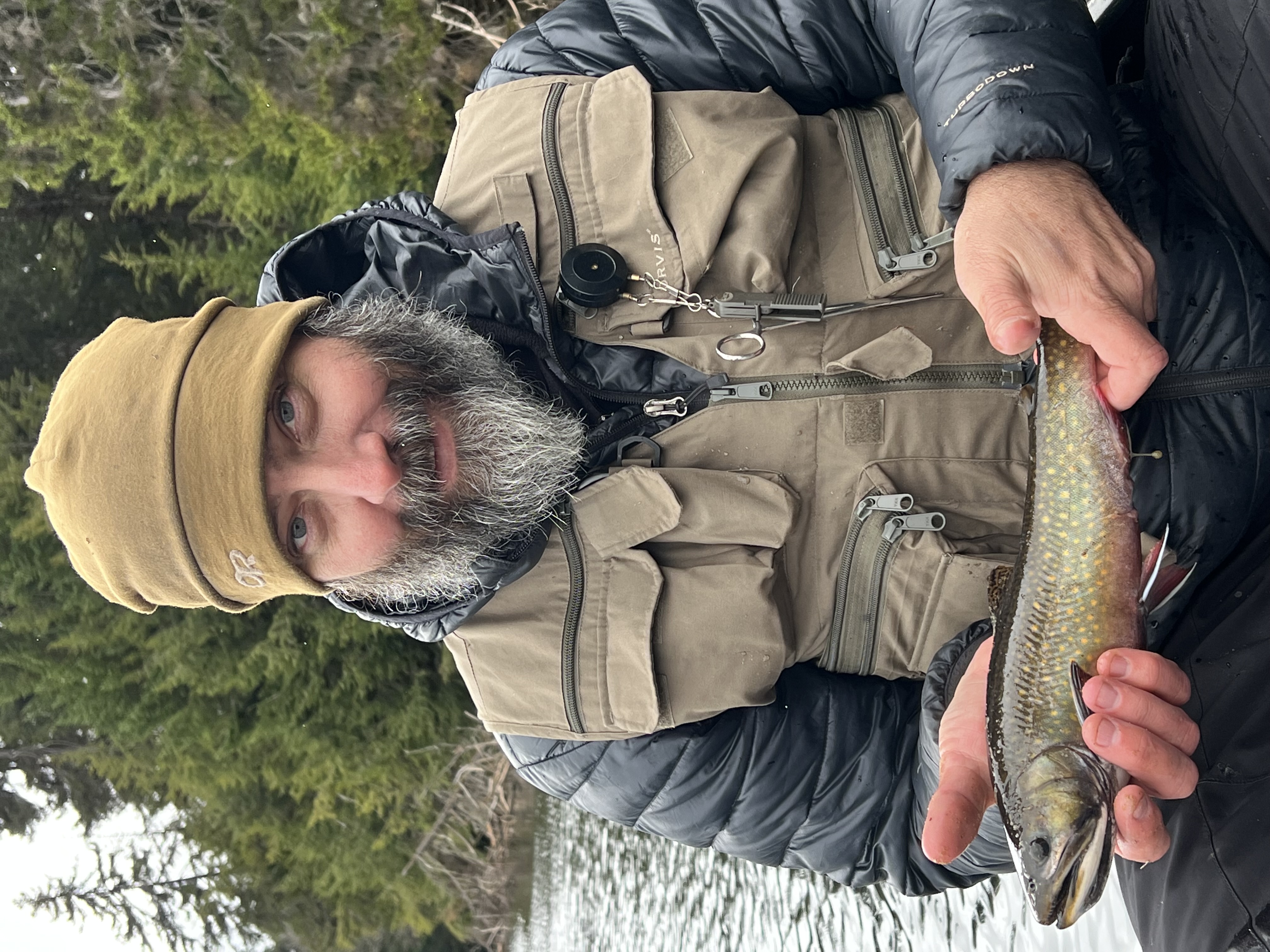 Angler holding freshly caught brook trout on Saranac River New York