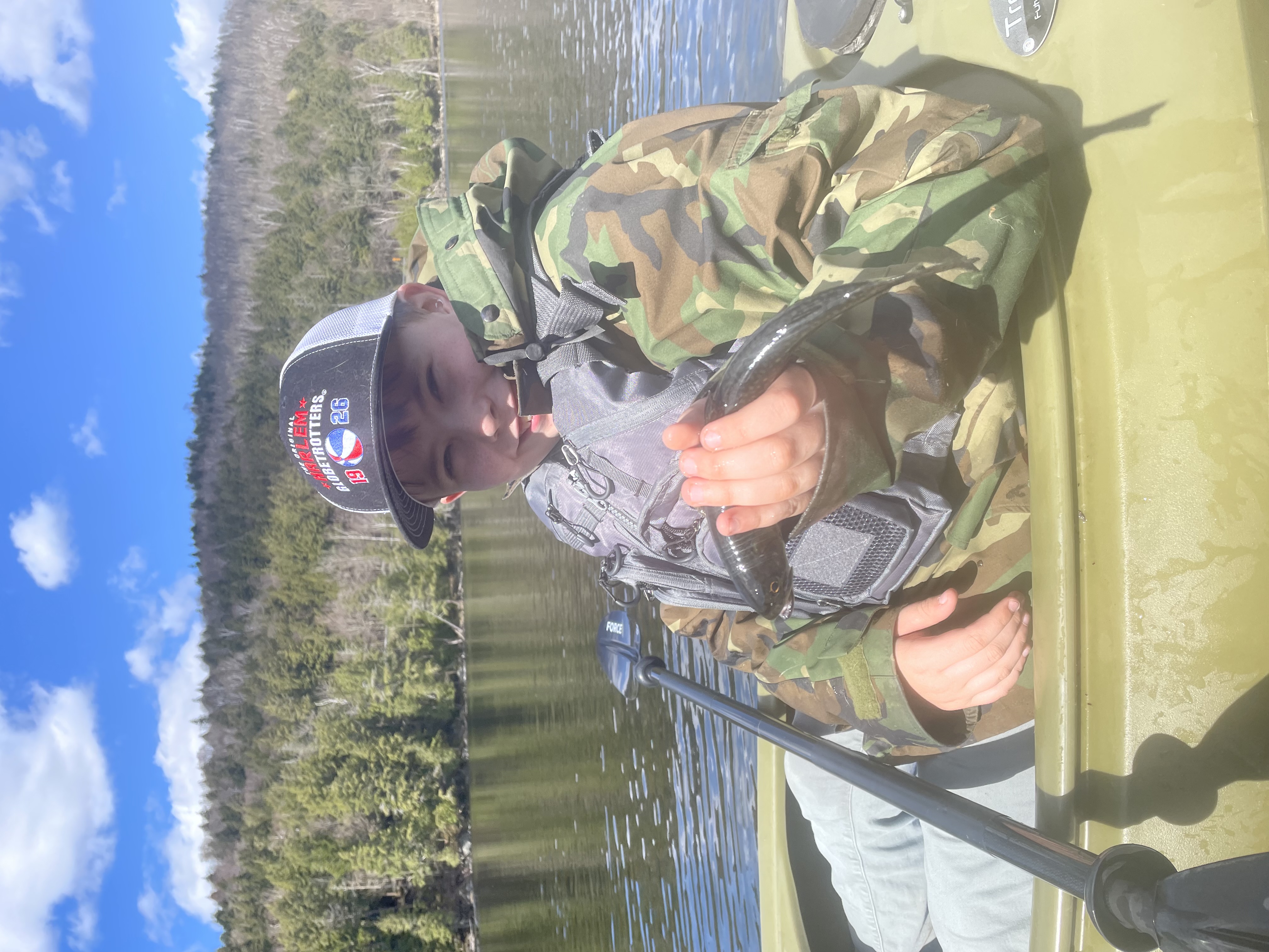 Angler fishing on Saranac River in New York with fishing rod over water