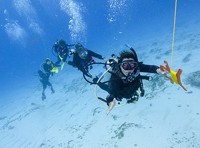Scuba divers drift diving with current over coral reef in West Palm Beach Florida waters