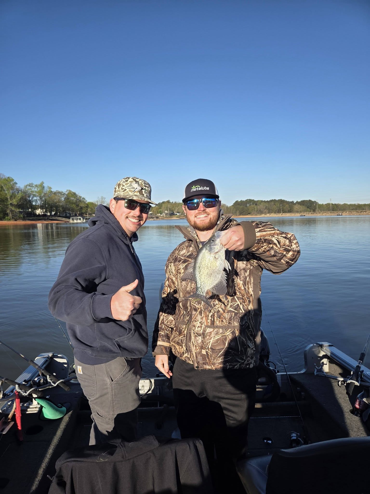 Two anglers displaying freshly caught crappie on fishing boat in Lyman SC