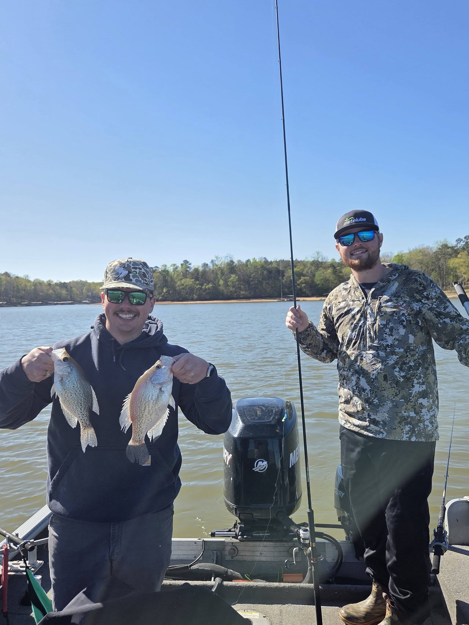 Two anglers displaying freshly caught crappie on fishing boat in Lyman SC