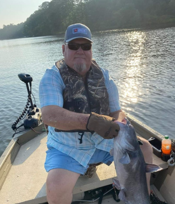 A fisherman holding a blue catfish in GA