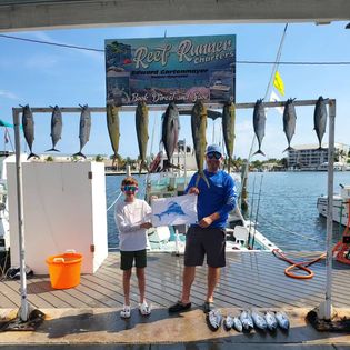 A man fishing for two big fish in the waters of Key West.