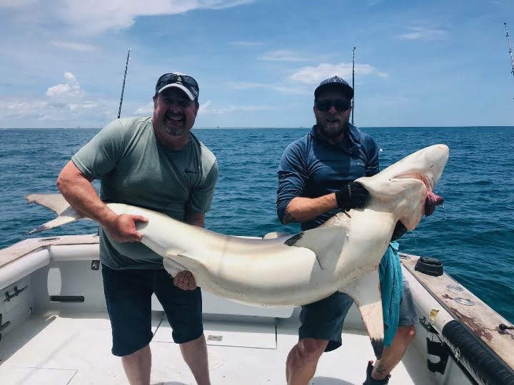 A pair of fishing enthusiasts enjoying the catch at Cape Canaveral