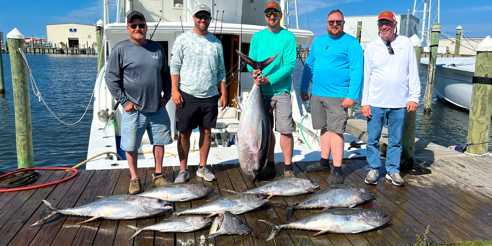Family fishing charter boat near Outer Banks coast with anglers catching bluefish and mackerel