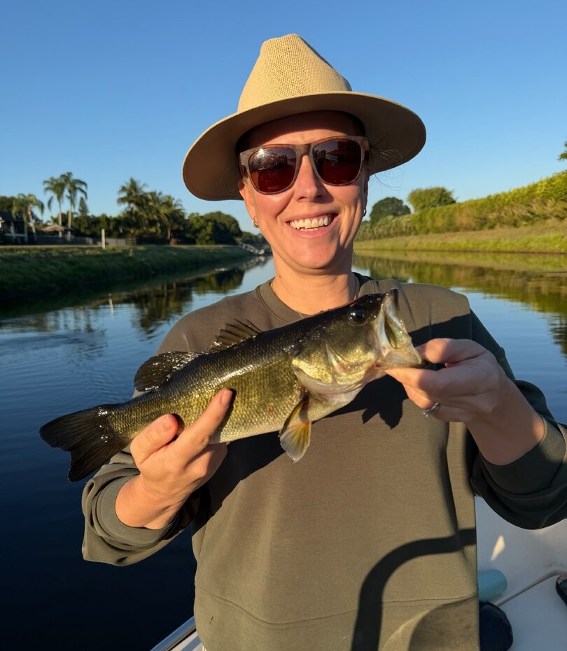 Angler holding freshly caught bass on boat in Fort Lauderdale FL waterway
