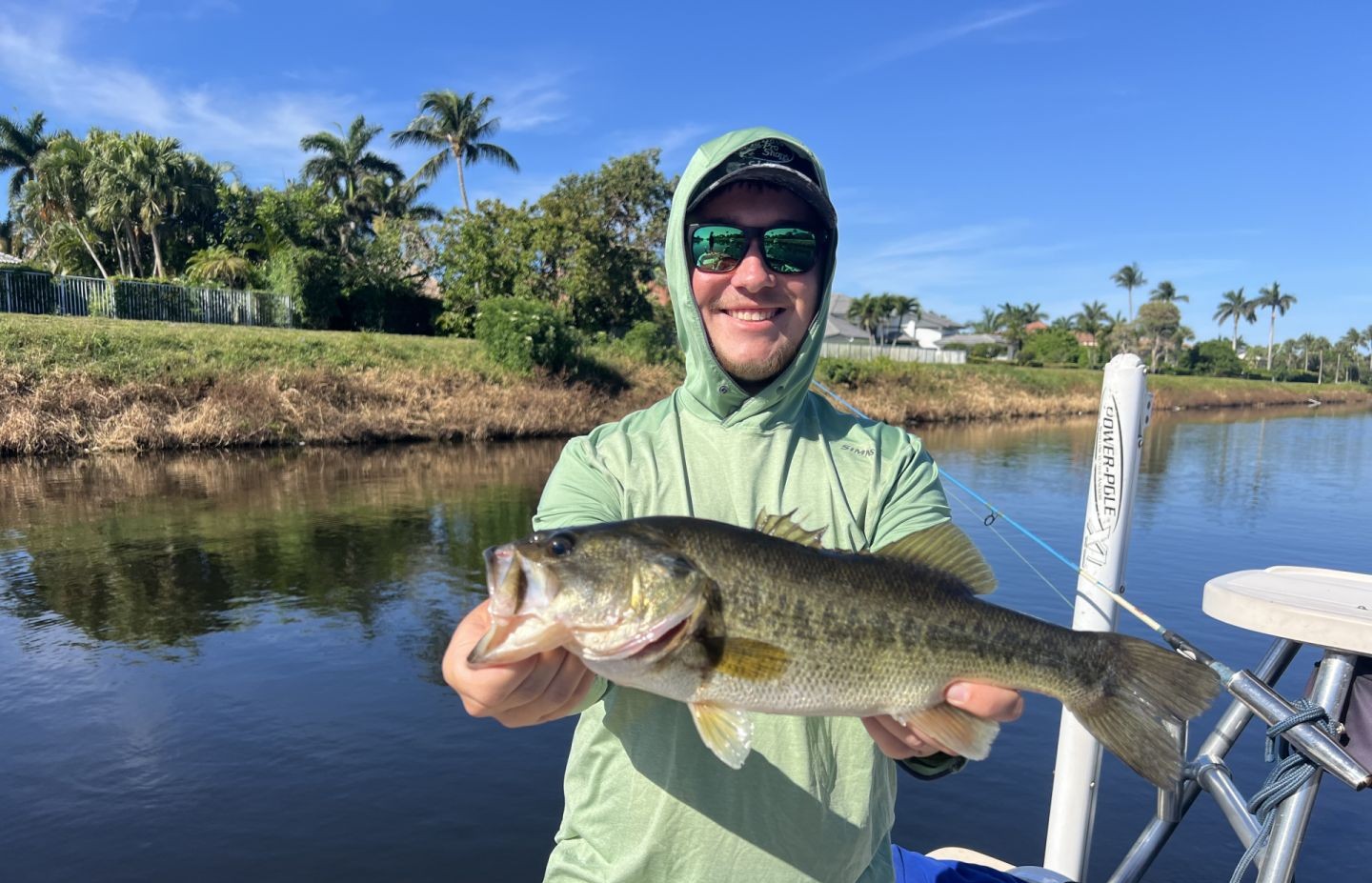 Angler holding freshly caught bass while fishing from boat in Fort Lauderdale FL