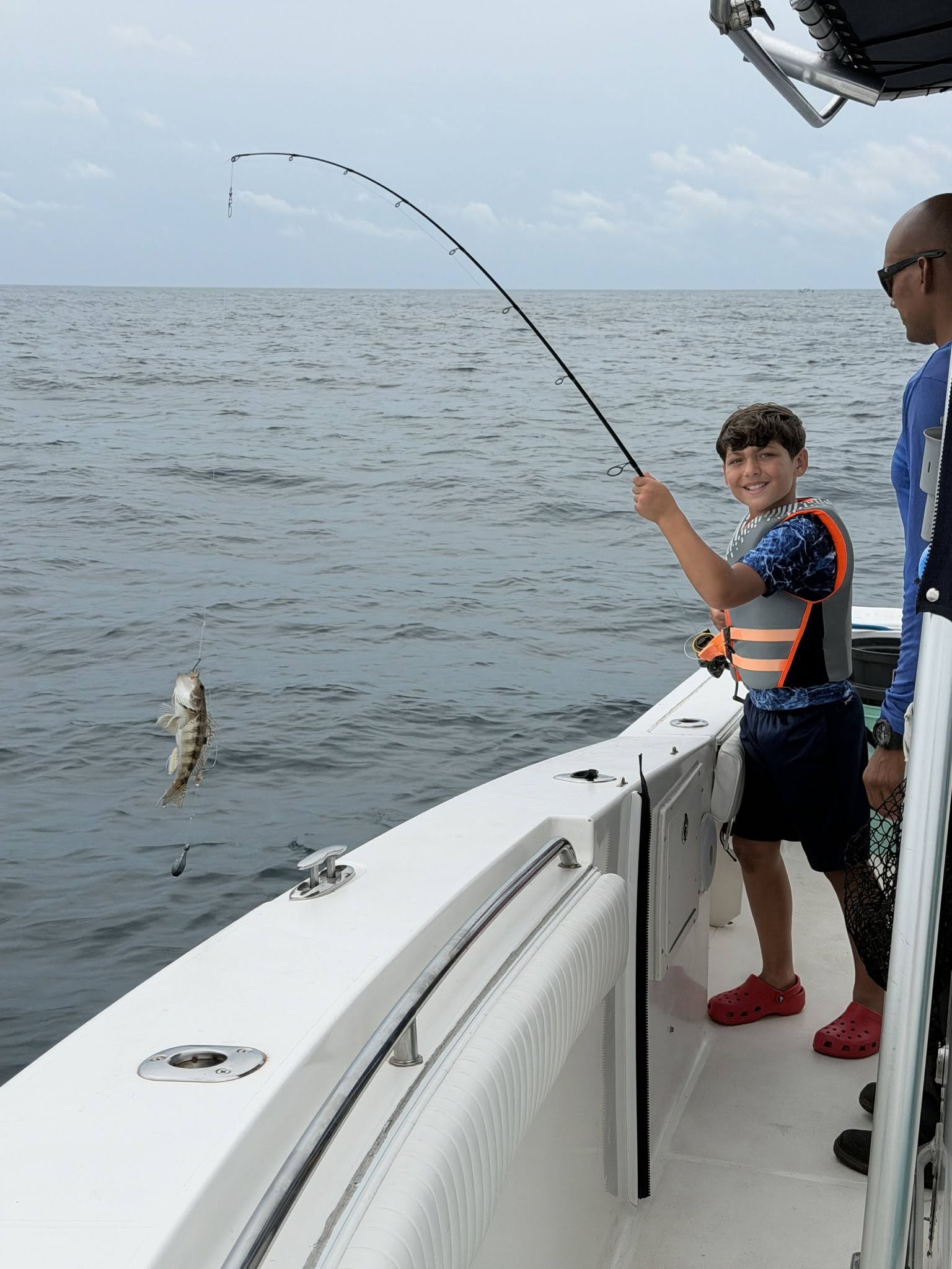 Fish caught on fishing line jumping out of water near boat at Wrightsville Beach NC