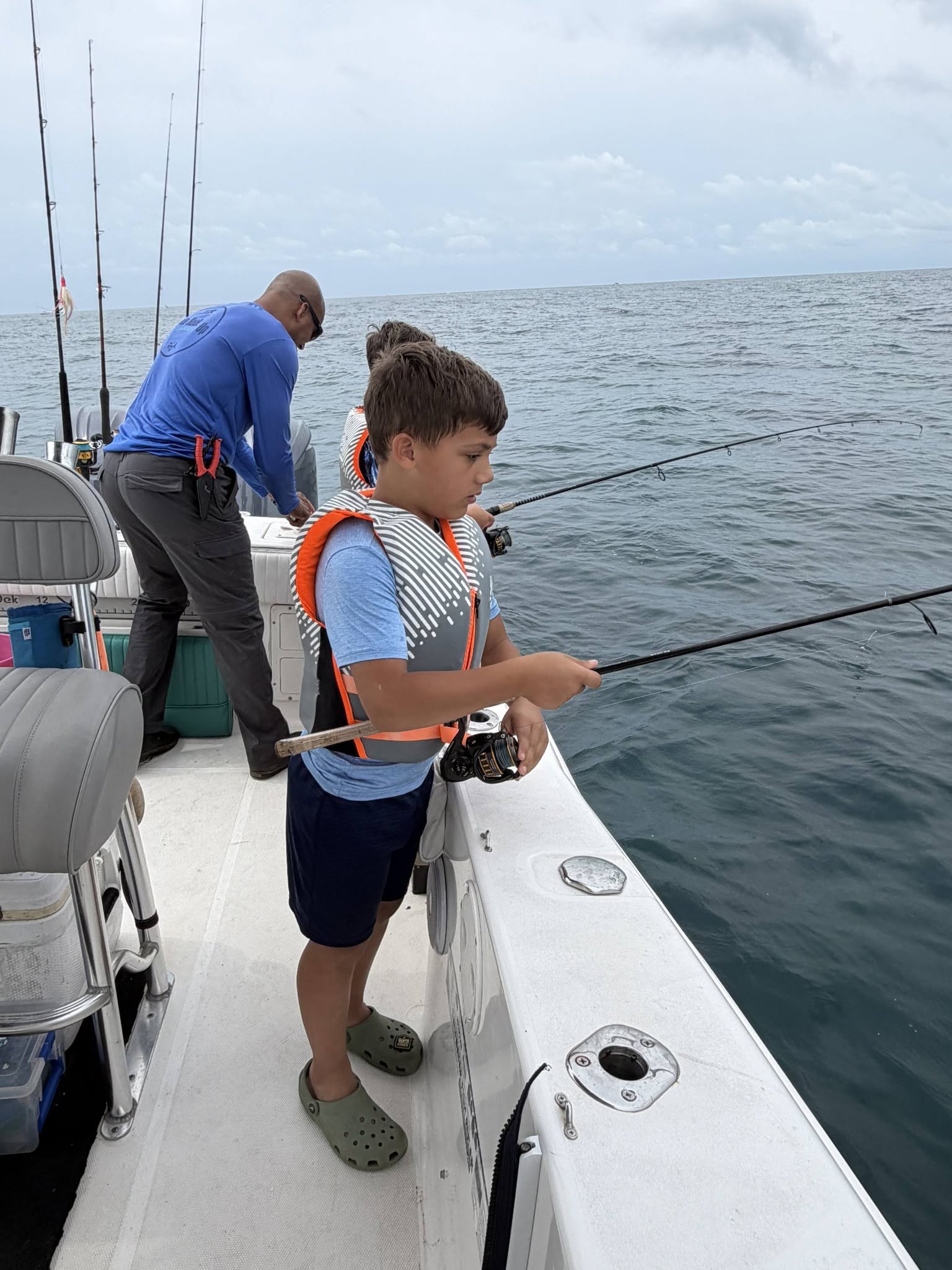 Fishing from boat deck at Wrightsville Beach NC with rod and reel