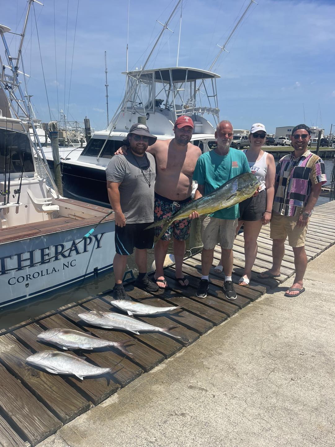 Fishing group displays mahi mahi and greater amberjack catch on dock in Corolla NC