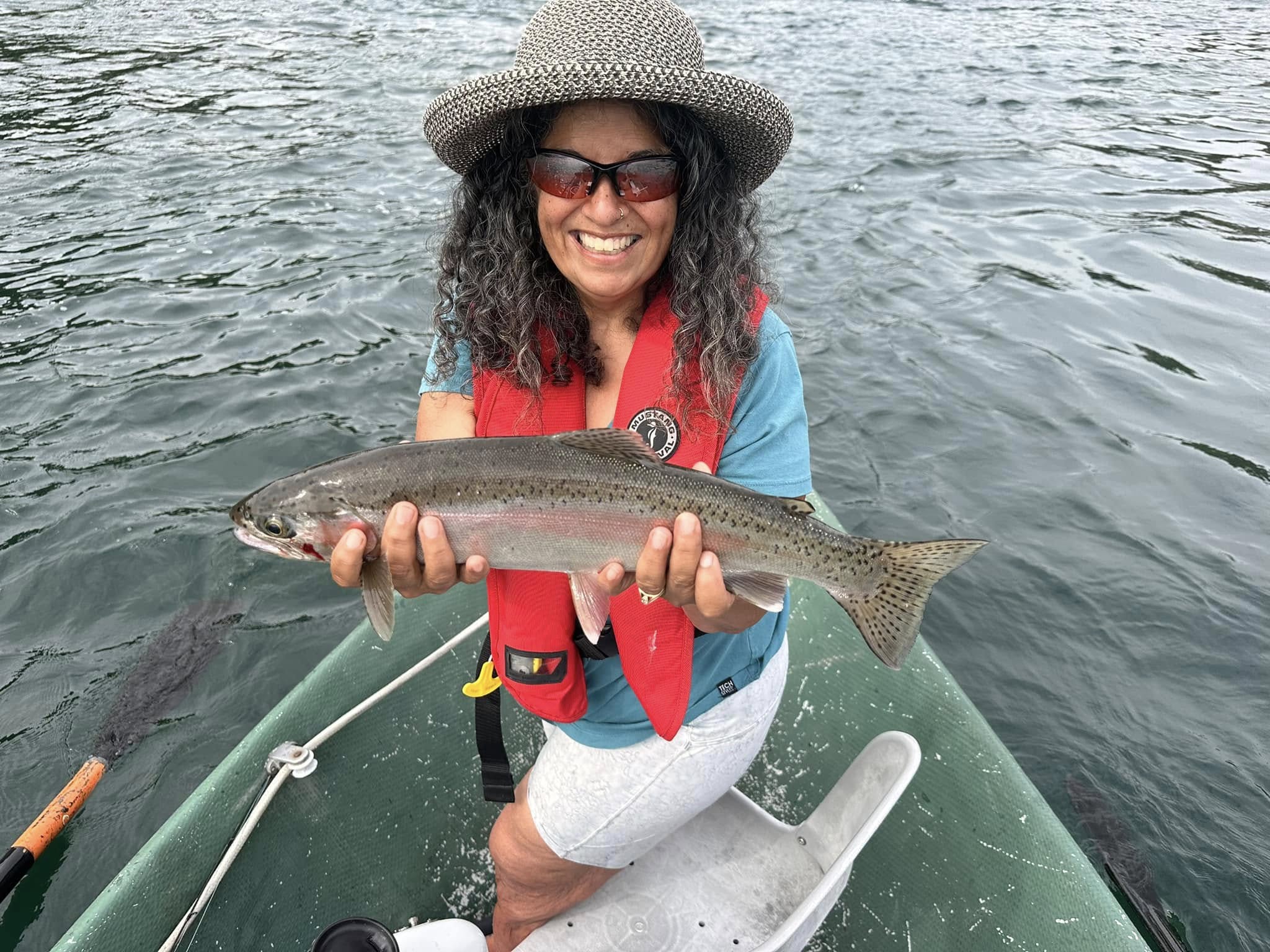 Angler catching a beautiful rainbow trout in BC