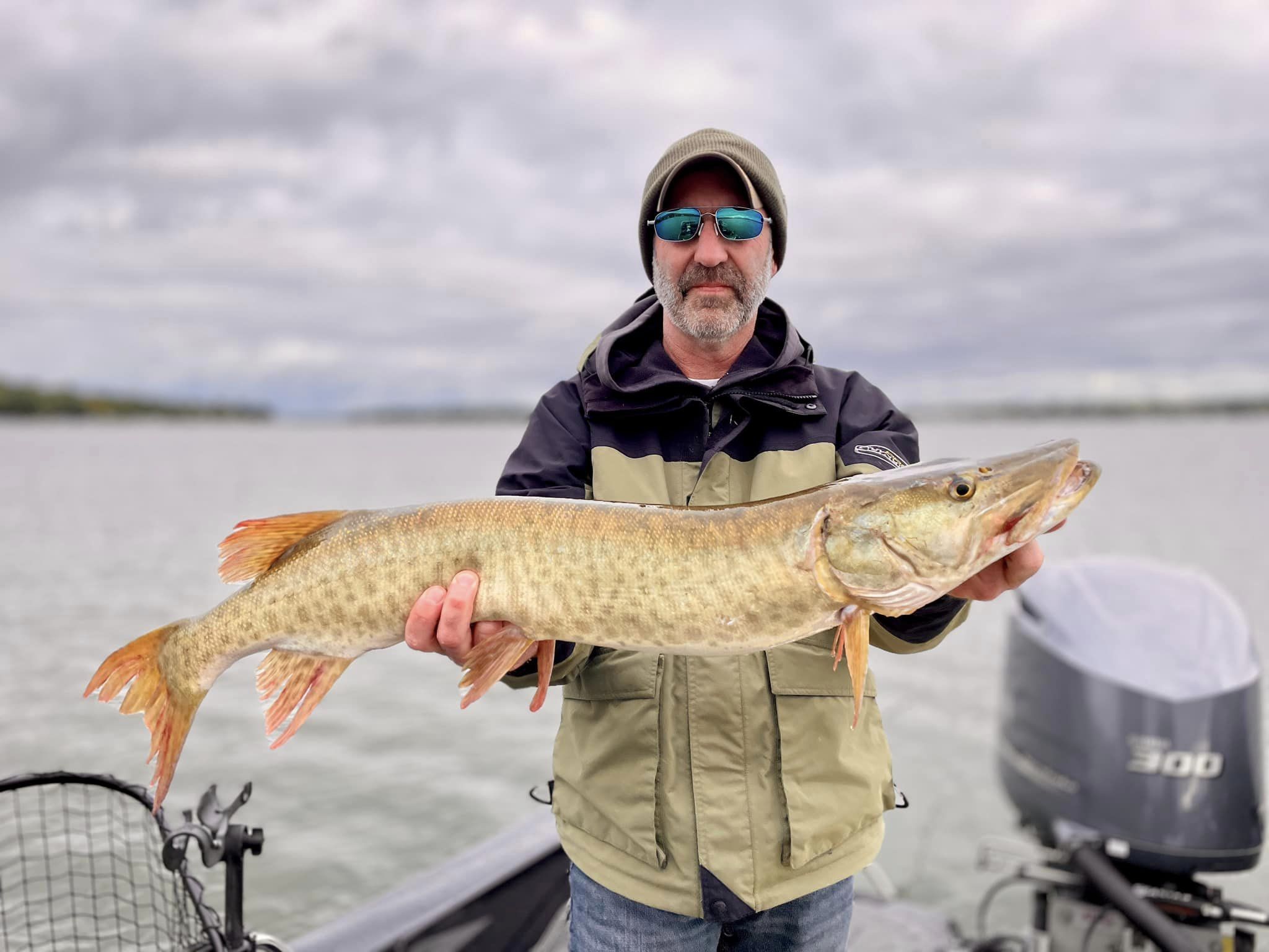 A angler holding a large muskellunge fish caught in WI