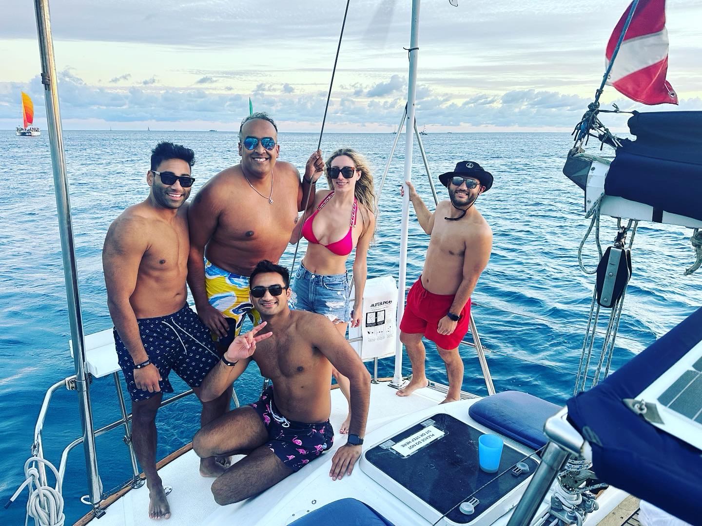 Group enjoying cruise on sailboat in Honolulu HI waters with ocean horizon view