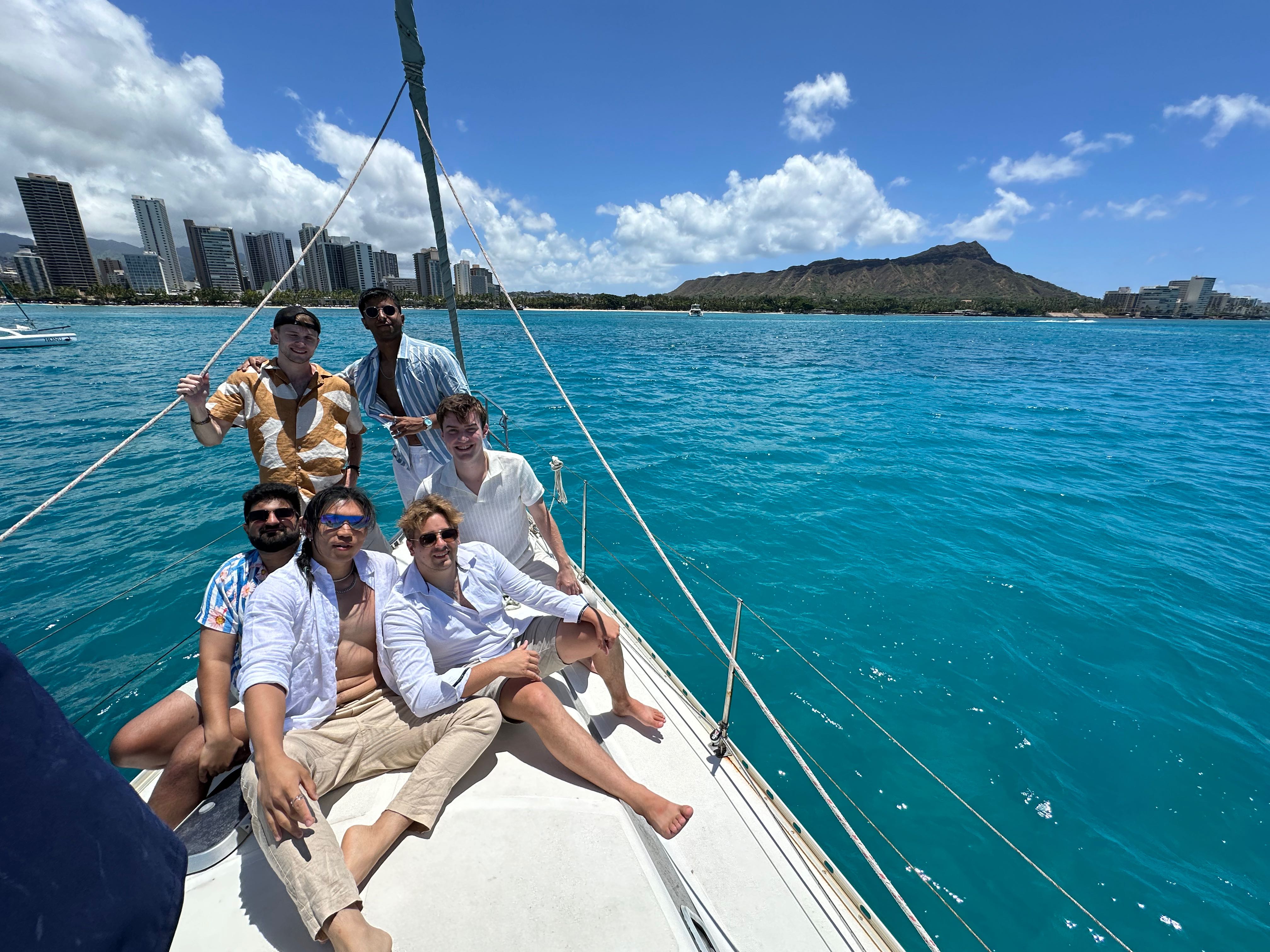 Group enjoying sailing cruise with Diamond Head and Honolulu skyline in background