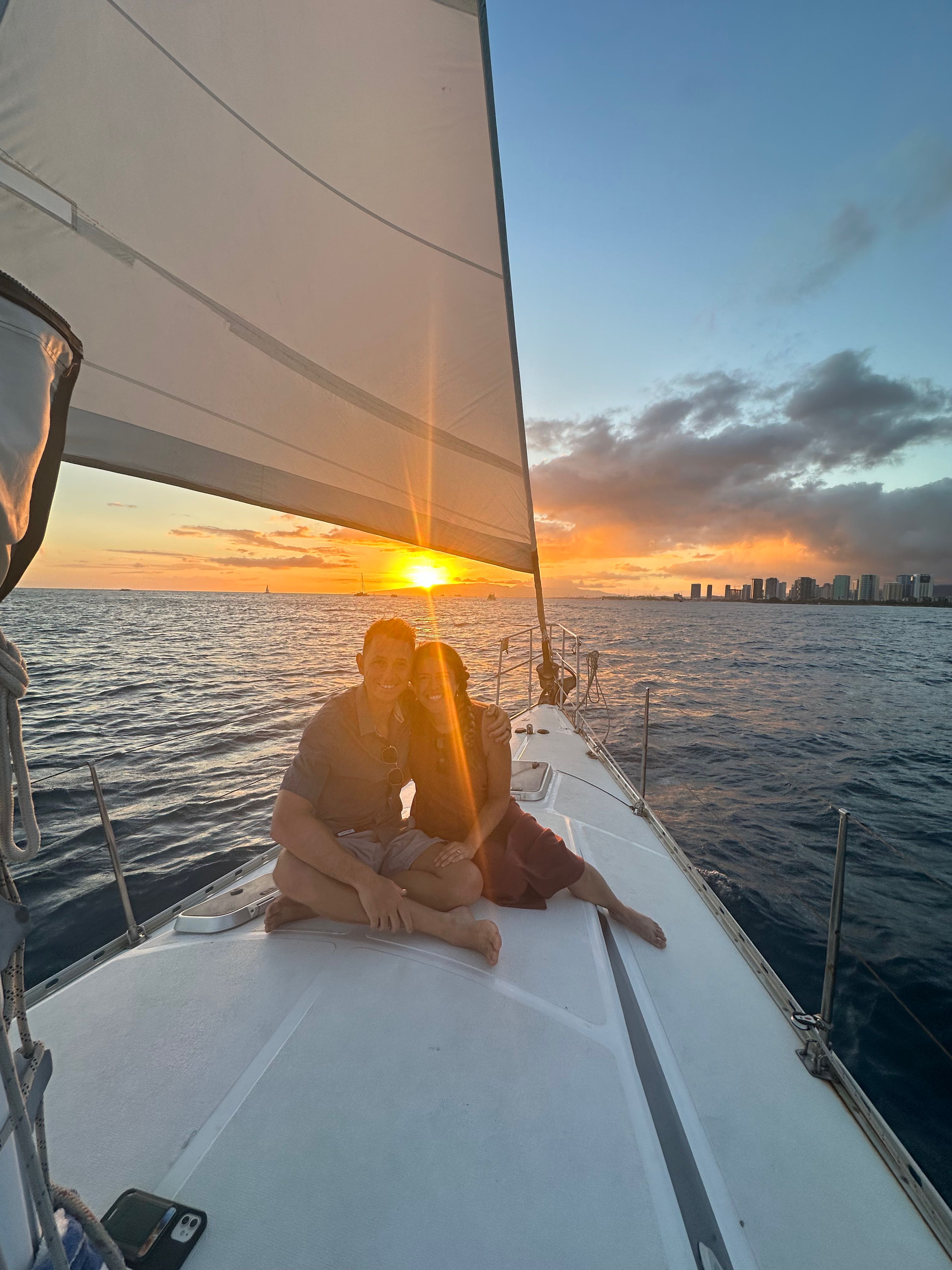 Sunset cruise on sailboat in Honolulu waters with city skyline visible in background
