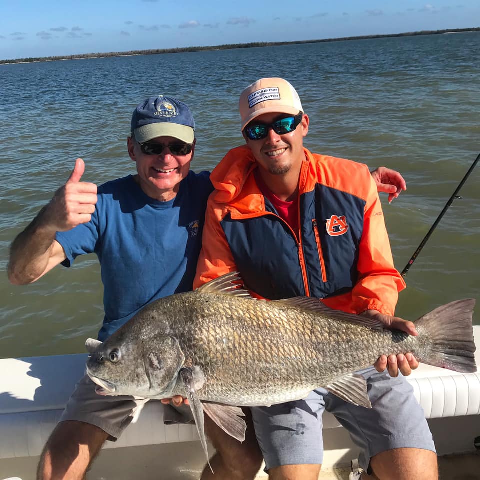 A photo of two people fishing for a black drum fish in Goodland