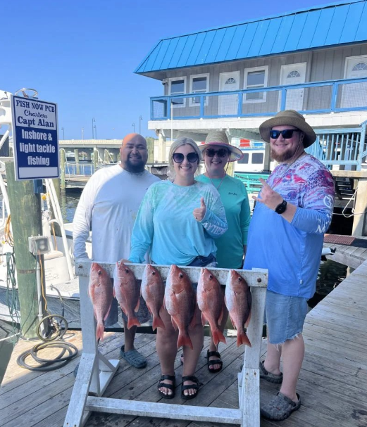 Red snapper fishing catch displayed on dock in Panama City FL with charter boat