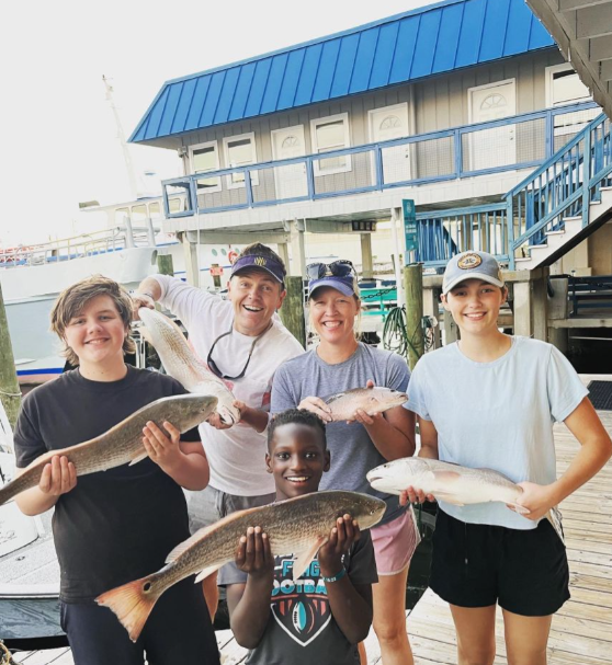 Successful redfish fishing trip in Panama City FL with multiple catches displayed on dock