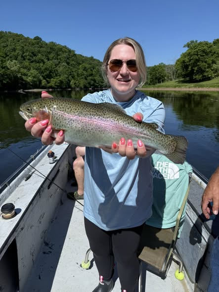 Rainbow trout caught fishing in Cotter AR held over boat on river