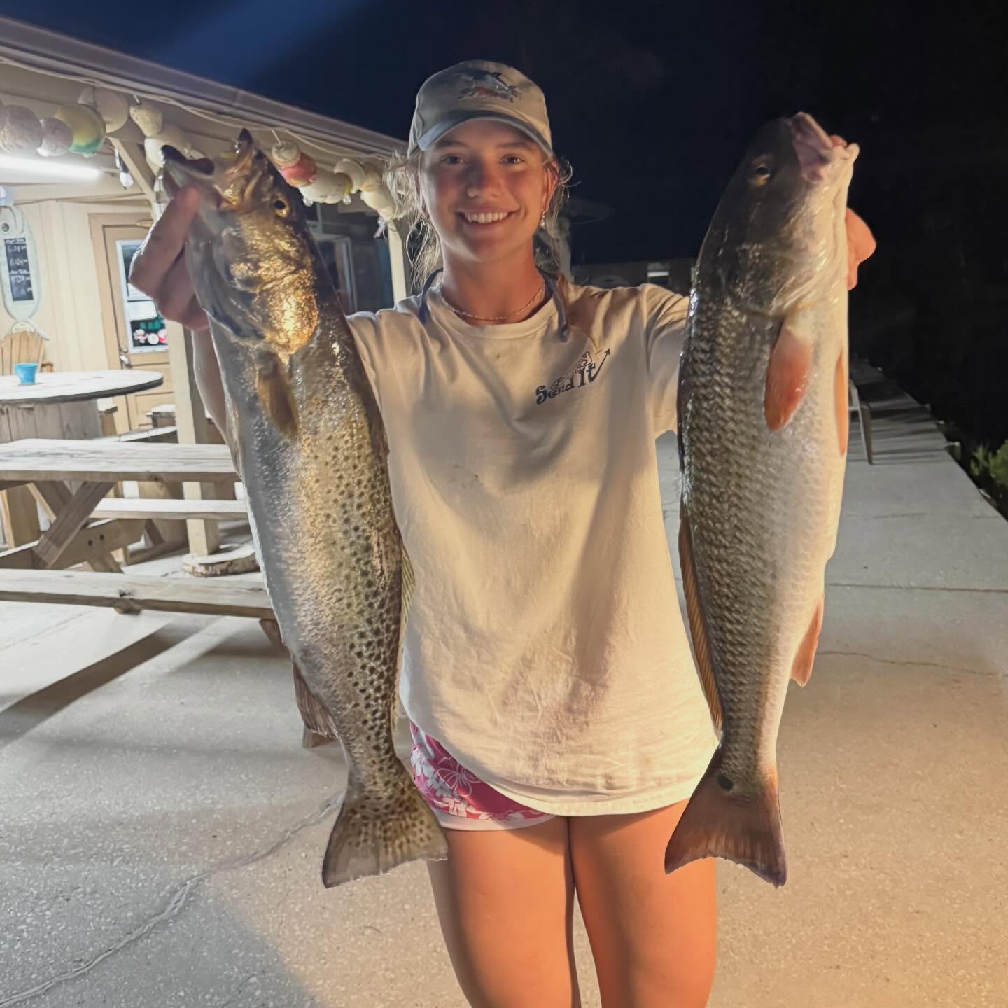 Two large speckled trout caught fishing in Spring Hill FL displayed on boat deck at night