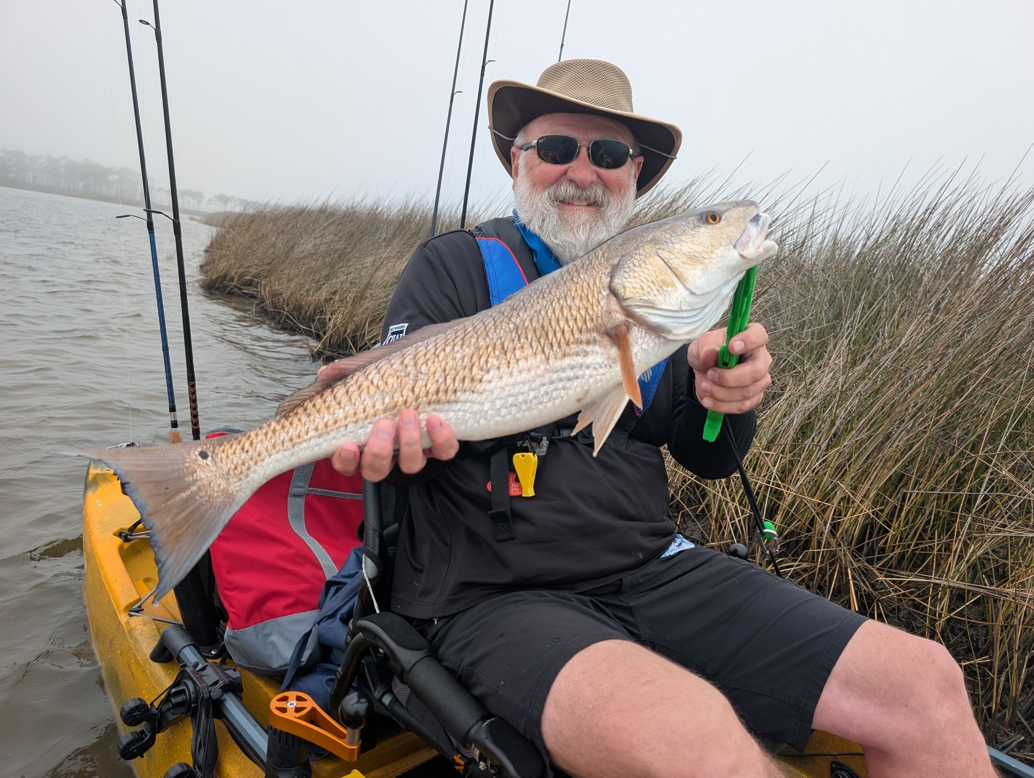 Angler holding large redfish caught while kayak fishing in Tallahassee FL