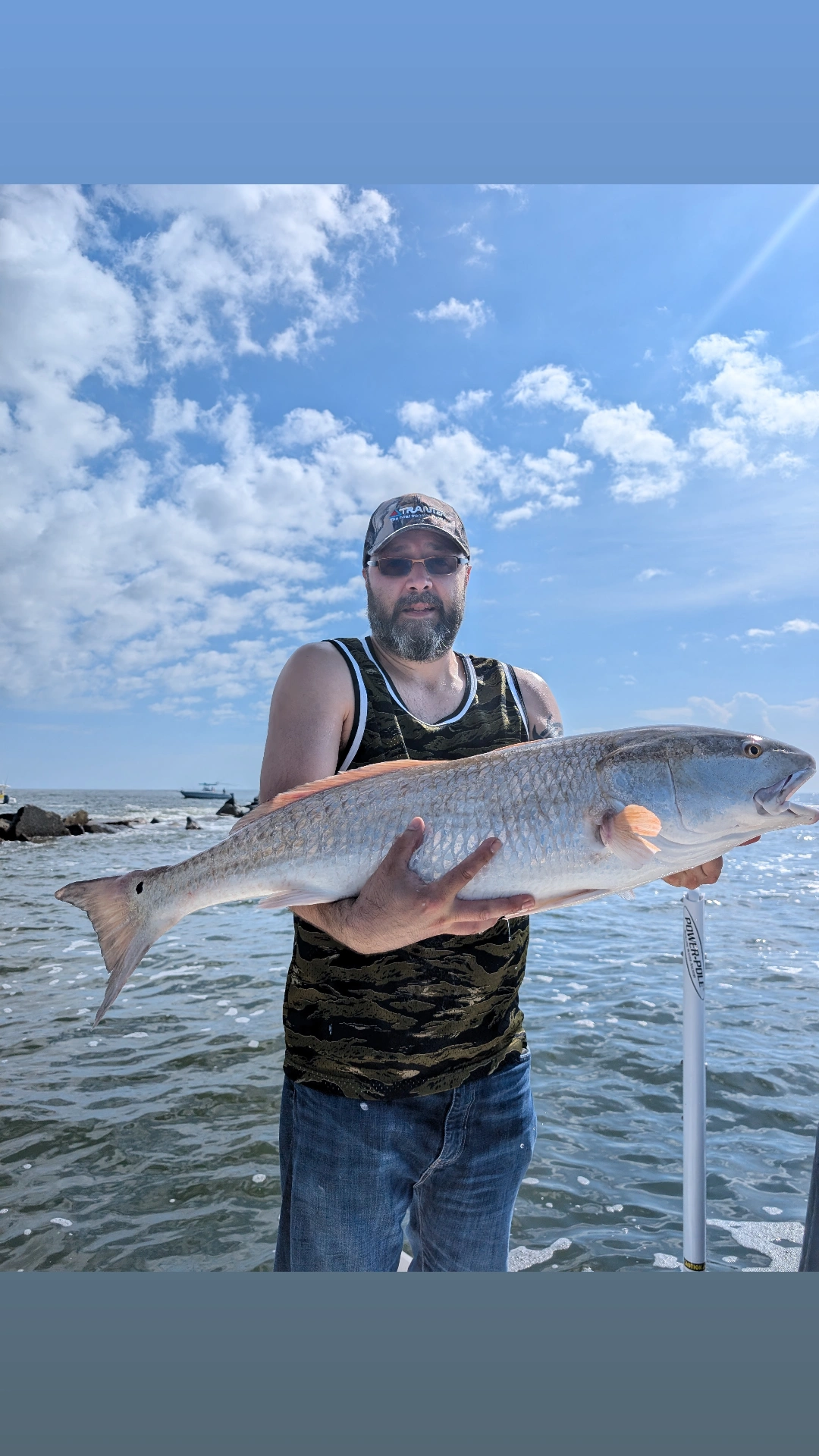 Angler holding caught redfish while fishing in Edgewater FL waters