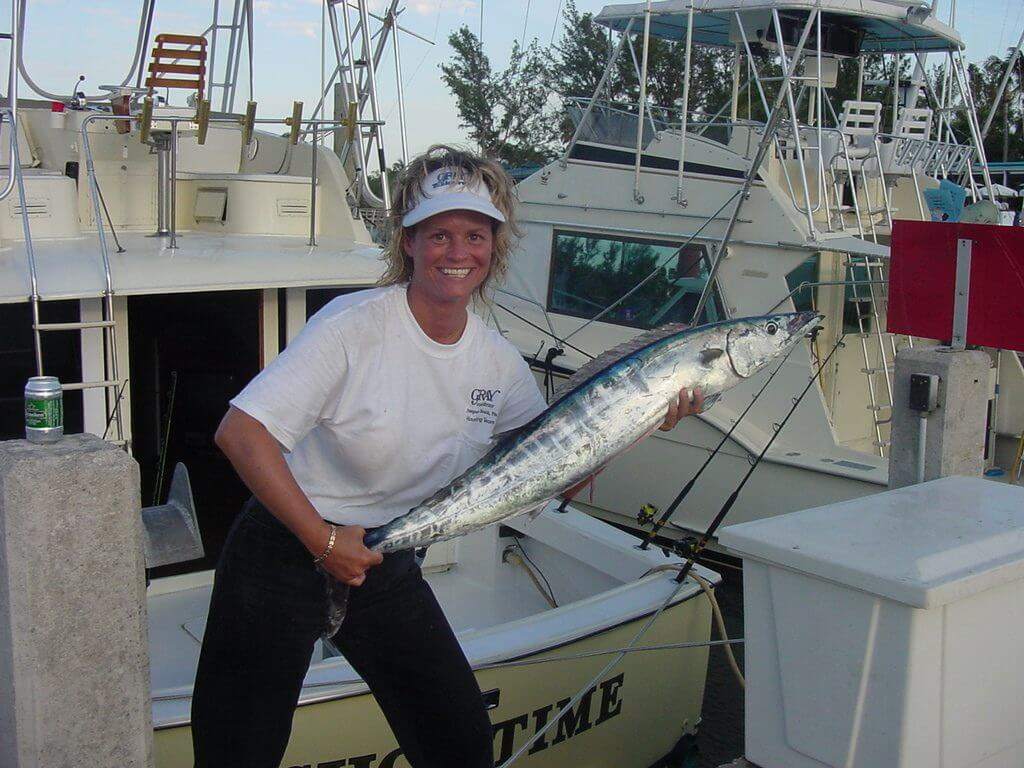 A fisherman holding a large king mackerel fish in West Palm Beach