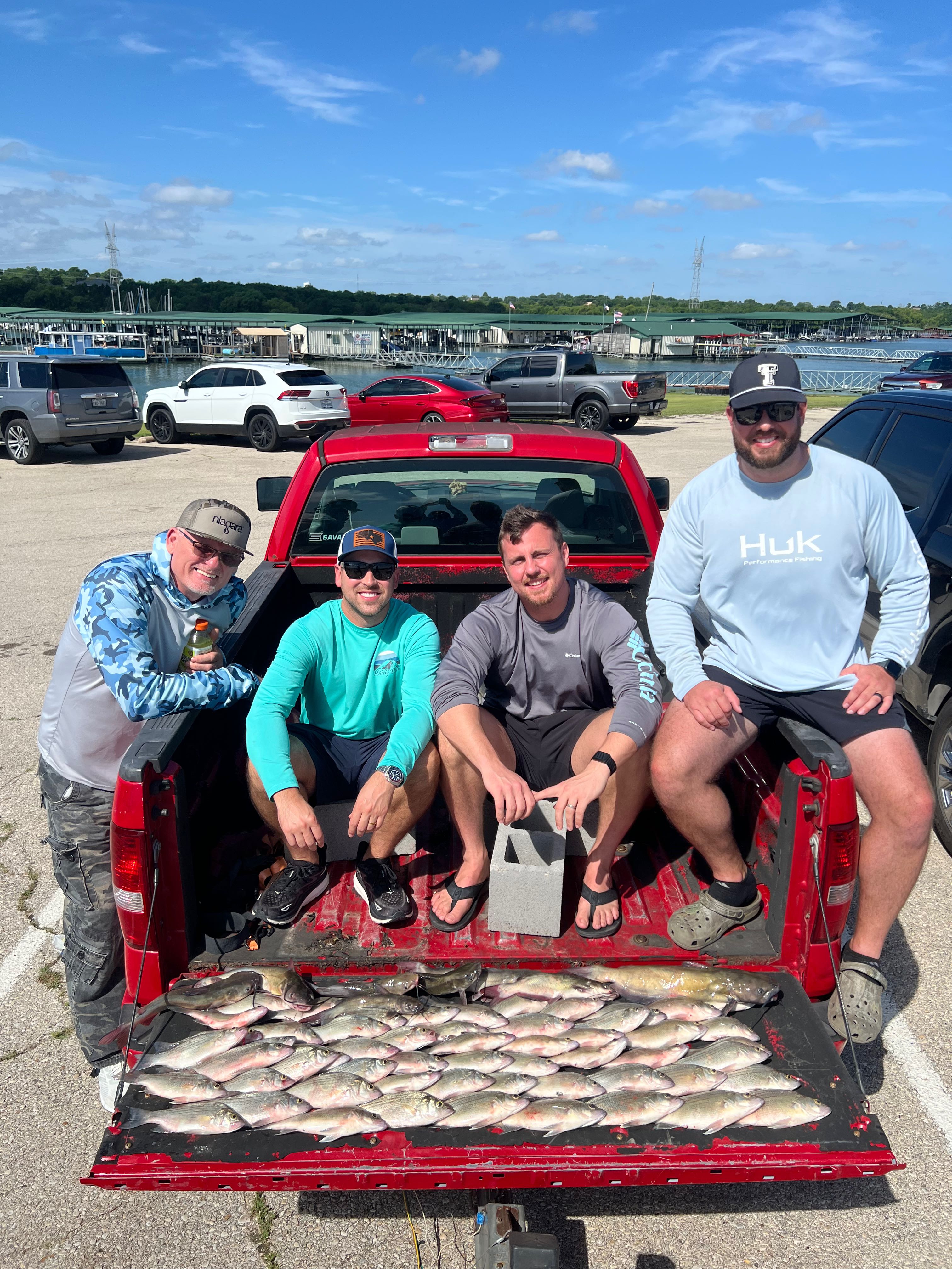Successful fishing trip in Wylie TX with large catch of fish displayed in red truck bed