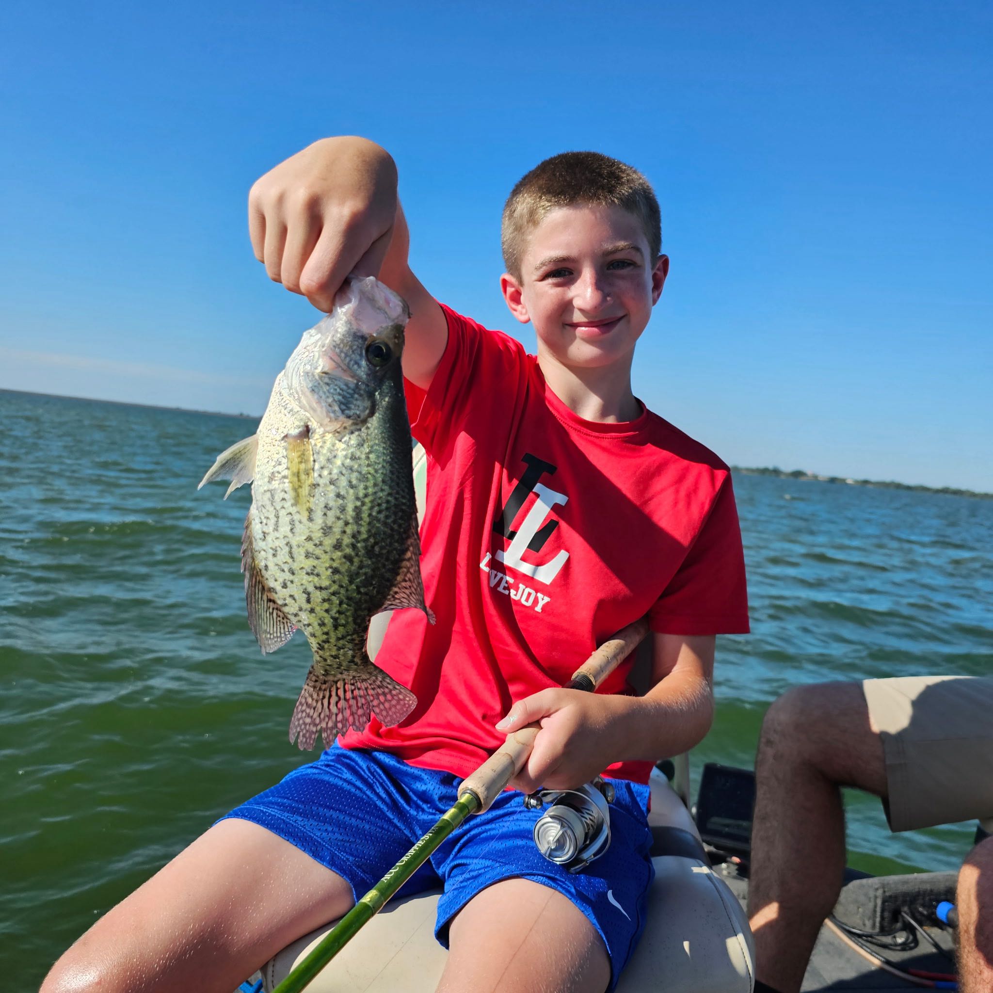 Freshly caught crappie being held up on fishing boat in Wylie TX waters
