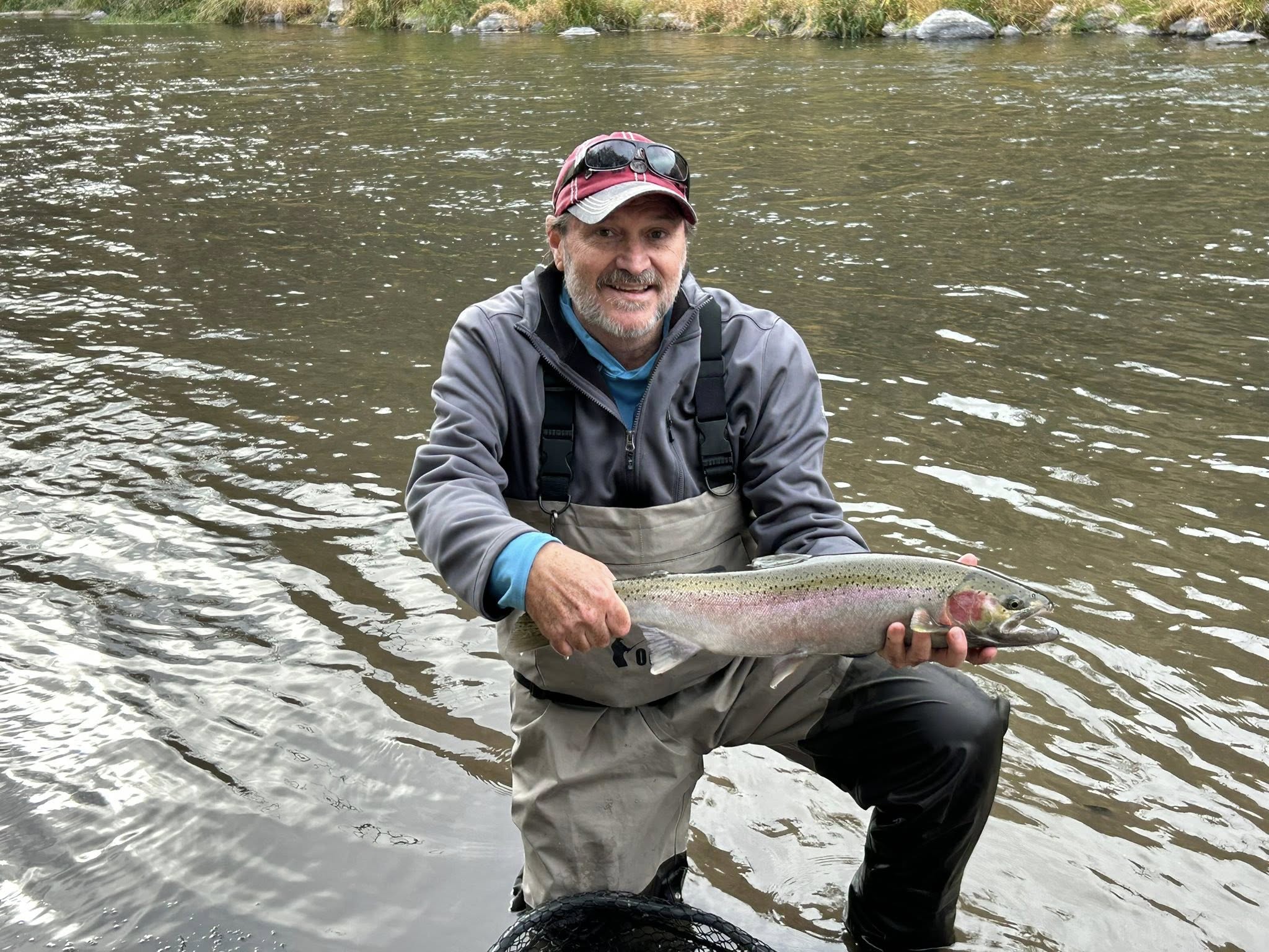 Angler catching a rainbow trout in Oregon