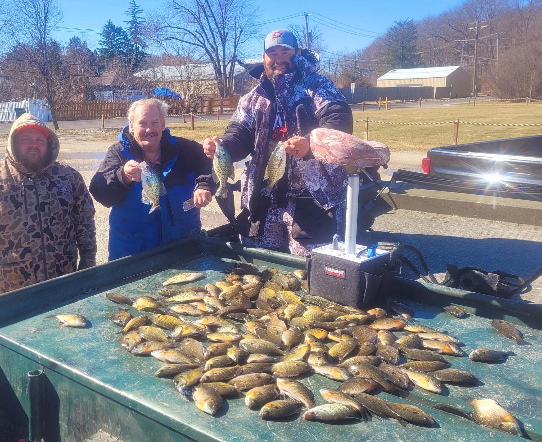 Two white crappie fish caught by three people in East Dundee