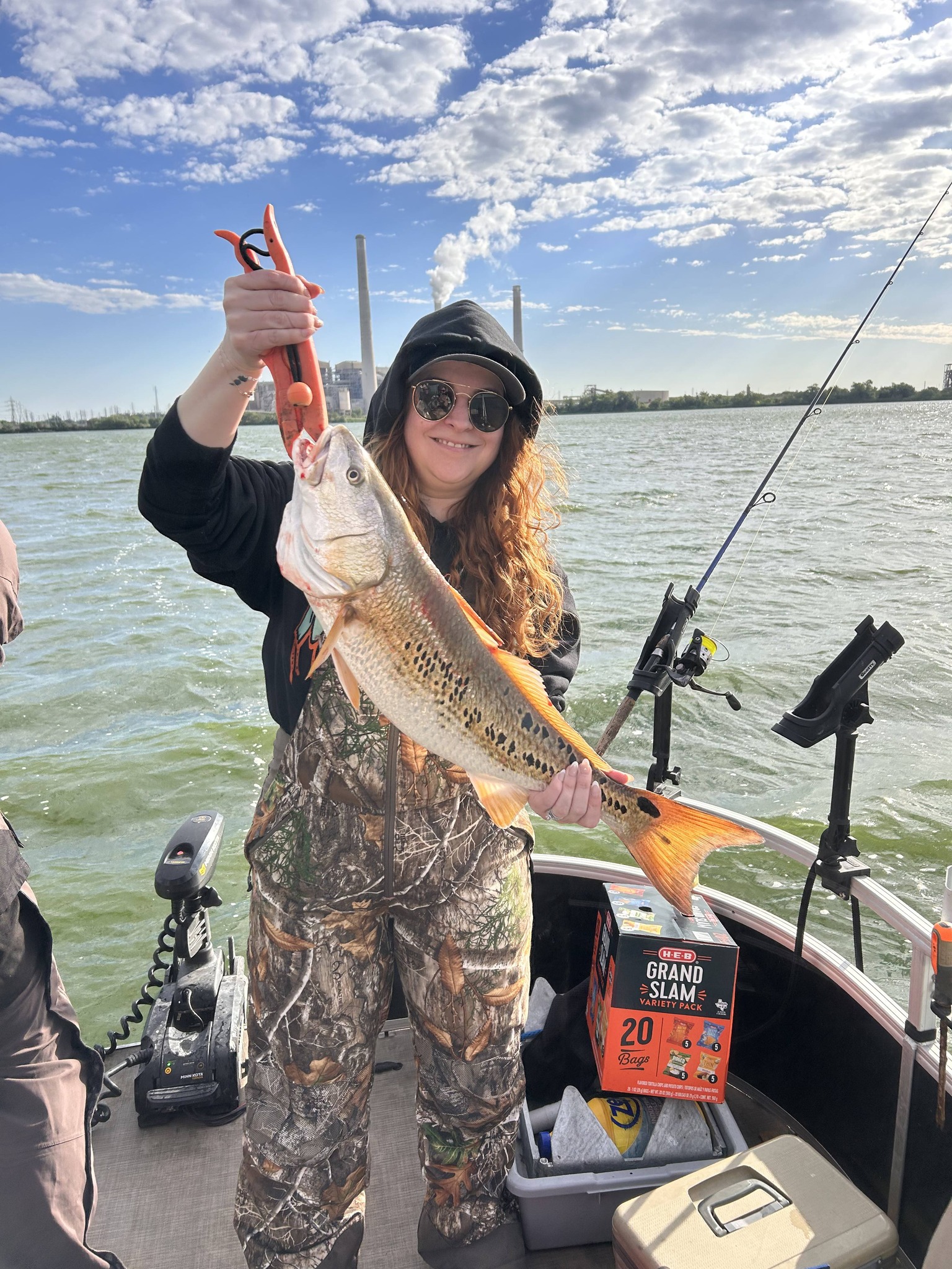 Angler holding freshly caught redfish on fishing boat in San Antonio TX waters