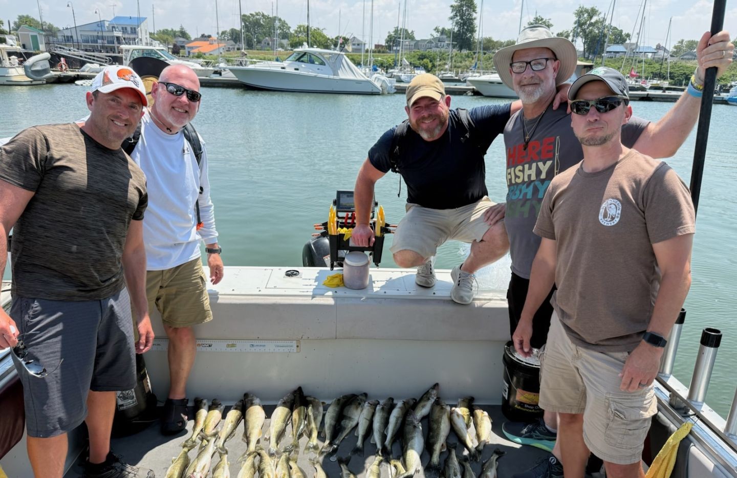 Five anglers displaying their catch of fish on a fishing boat at a marina in Lorain OH