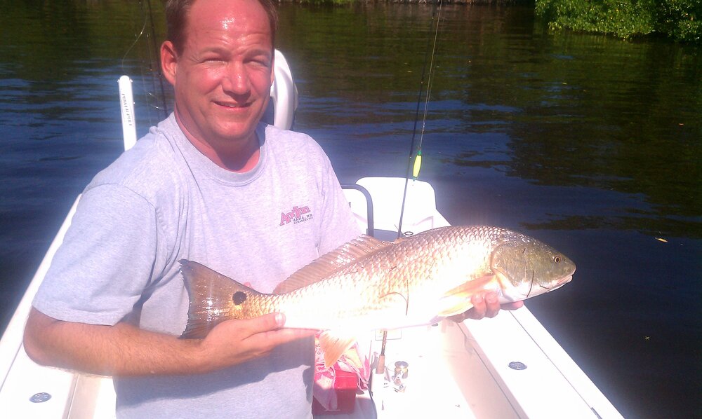 A fisherman holds a 17-inch redfish in FL