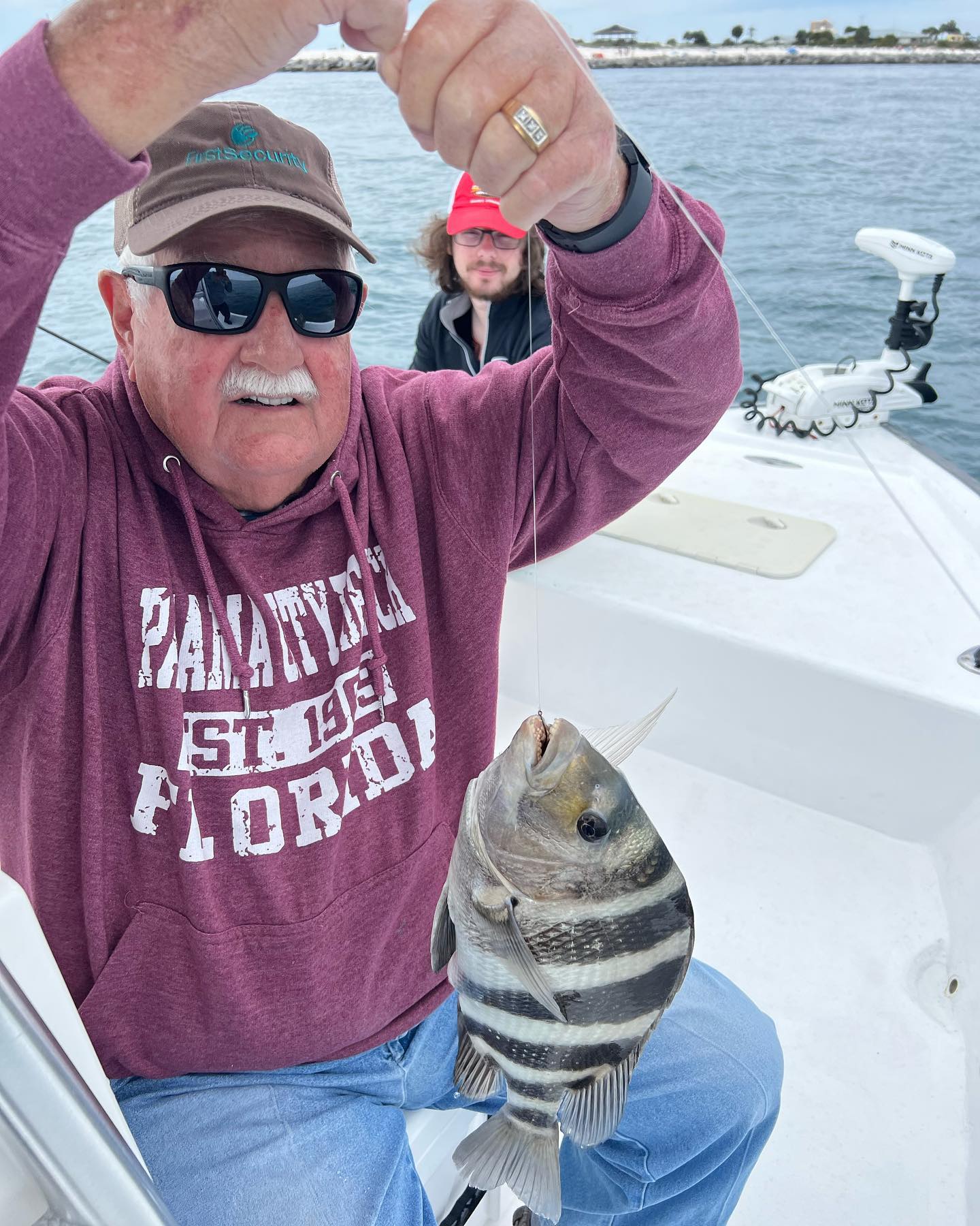 A fisherman holding a 11-inch sheepshead fish caught while fishing in FL