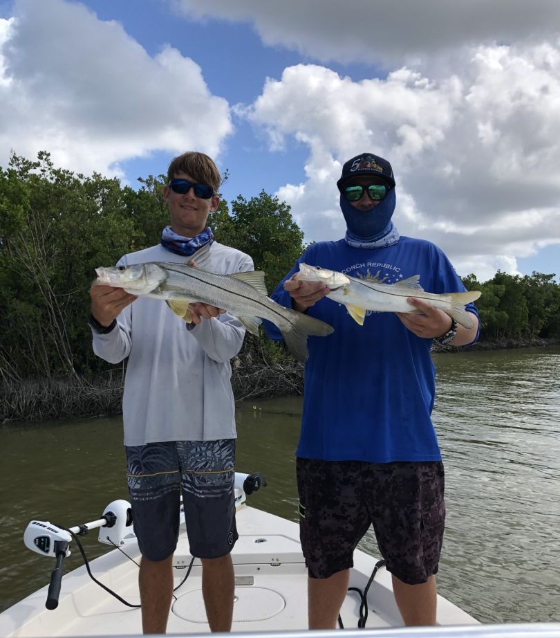 Two anglers holding snook caught during fishing charter in Islamorada FL