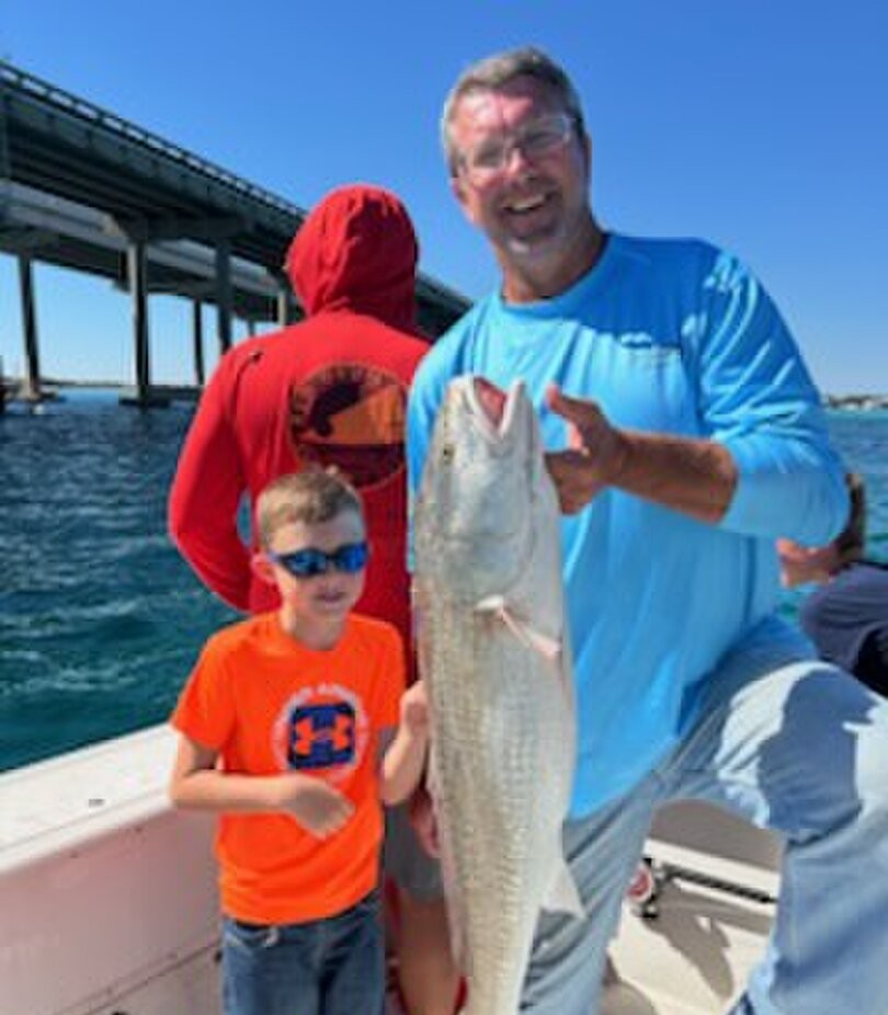 Redfish catch displayed on fishing boat in Shalimar FL with bridge in background