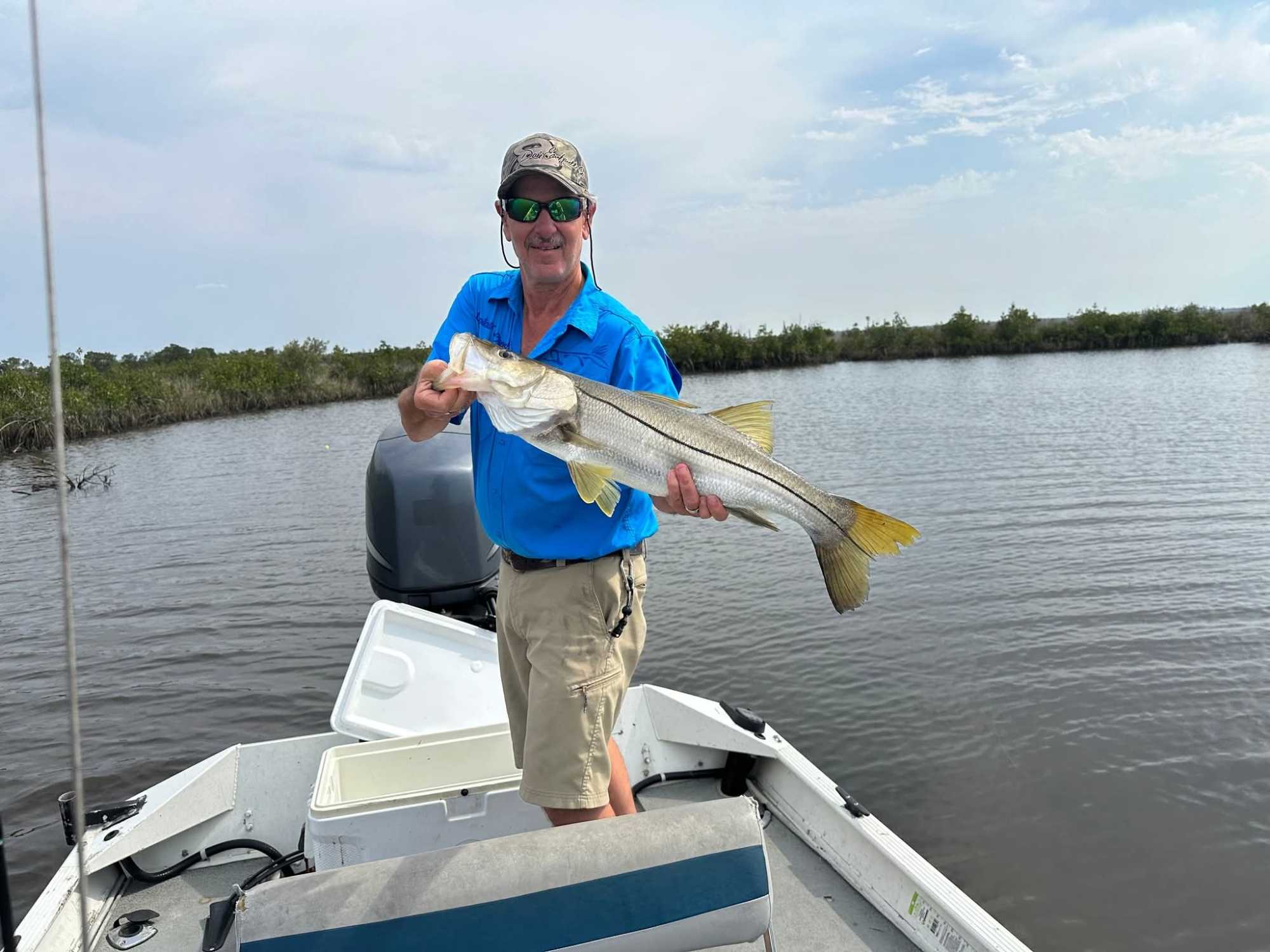 Angler holding caught snook on fishing boat in Brooksville Florida waters