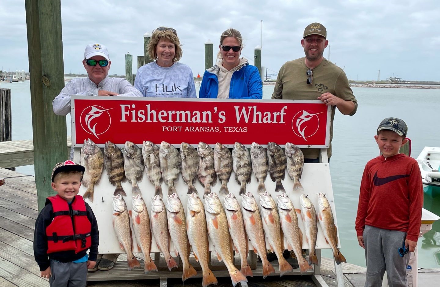 Successful fishing trip displaying multiple redfish catch at Fisherman's Wharf in Aransas Pass, Texas