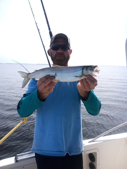 Angler holding freshly caught fish on boat in Altmar NY