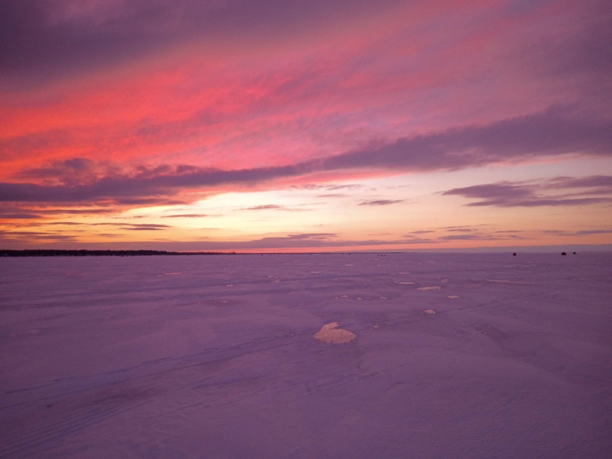 Frozen lake surface during colorful sunset in Altmar NY fishing location