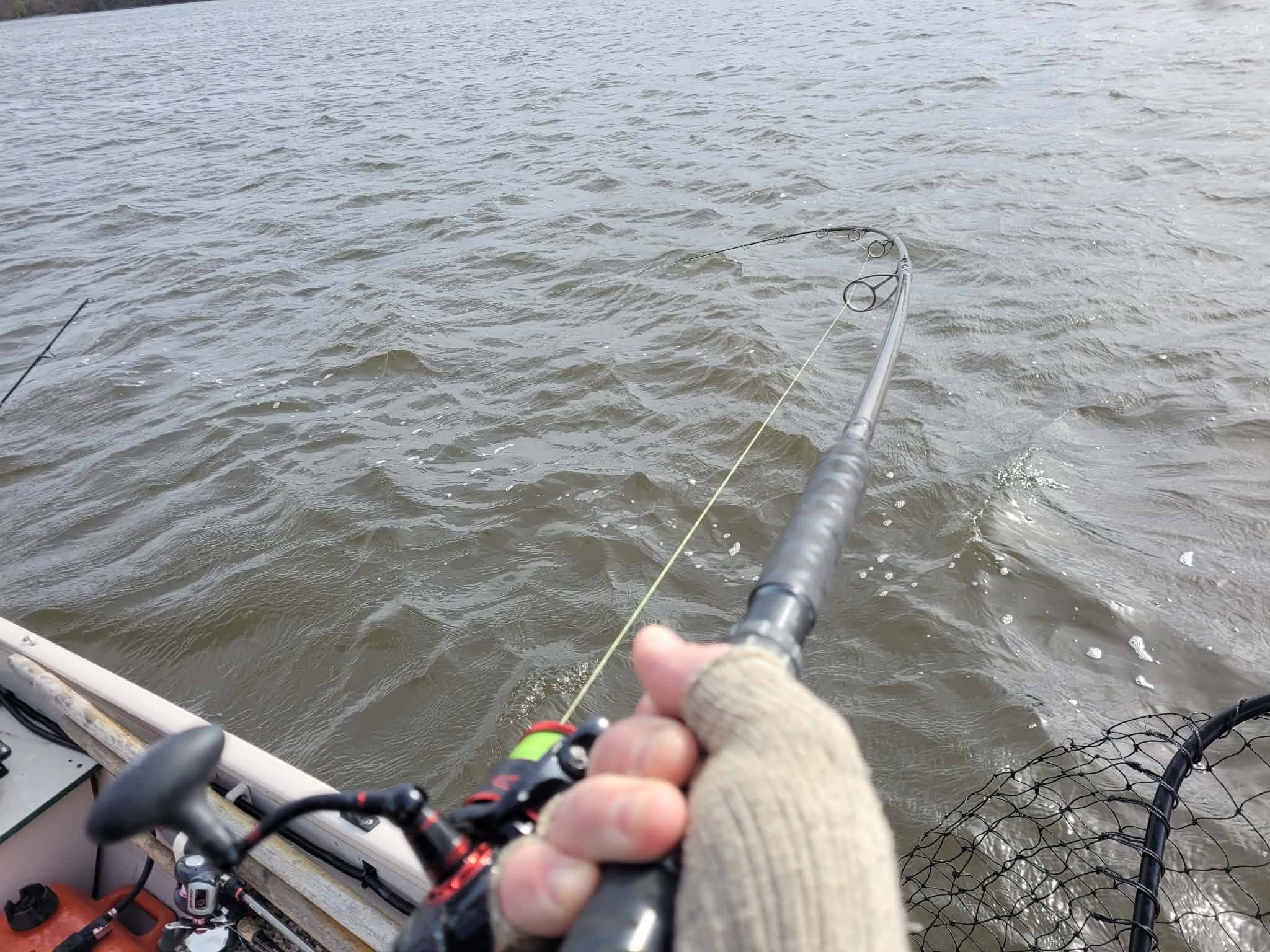 Fishing rod bent with tension over water in Altmar NY