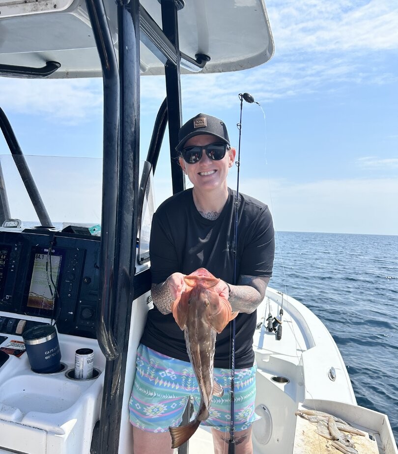 Angler holding freshly caught fish on fishing boat in Panama City Beach FL waters