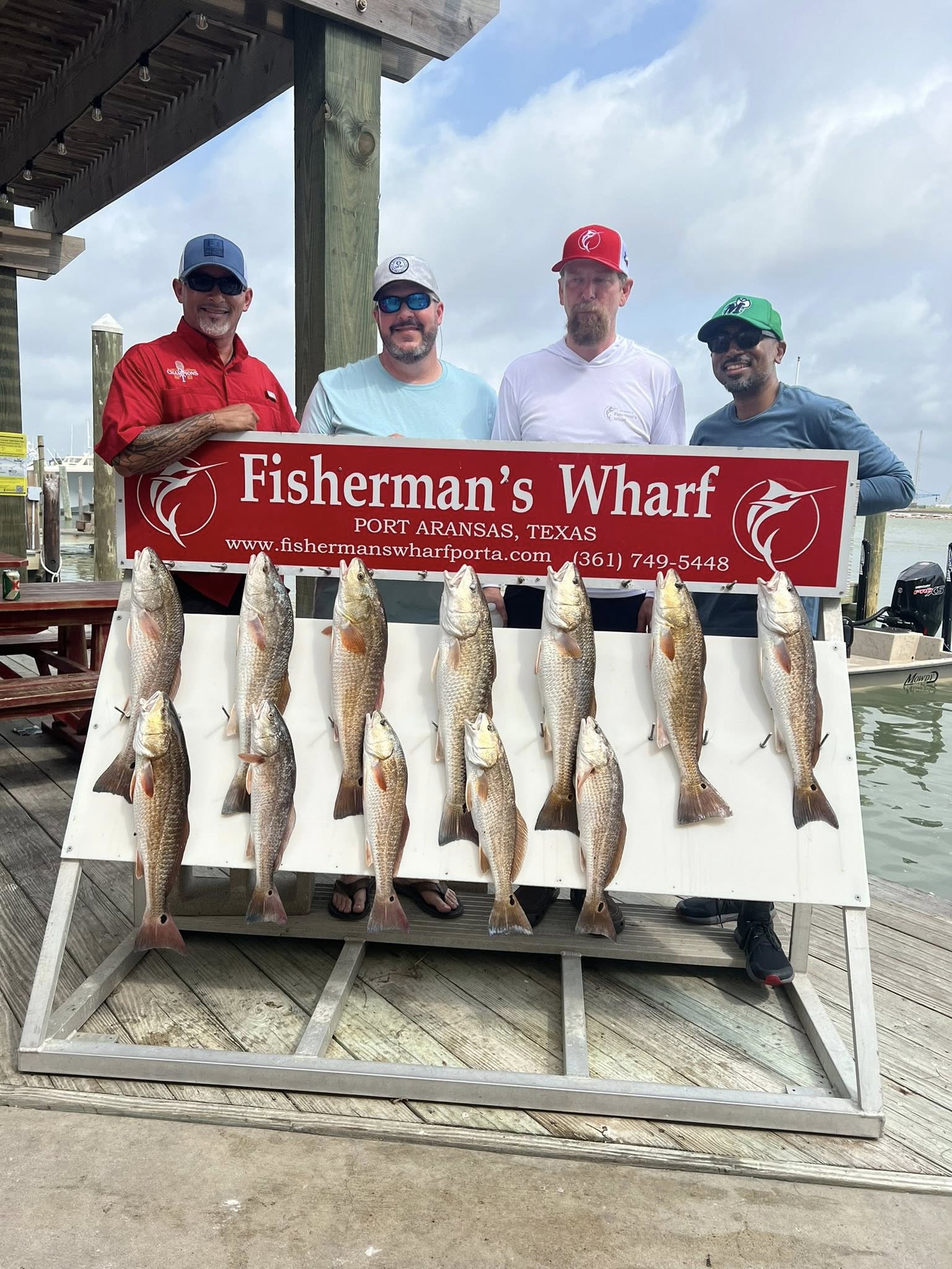 Display of ten redfish caught during fishing trip in Rockport TX at marina dock