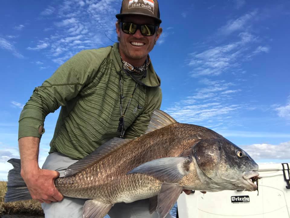 Angler with a large black drum fish in LA